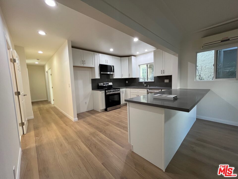 1530 5th Avenue Los Angeles, CA 90019 - Photo 3 of 9 a kitchen with stainless steel appliances granite countertop a sink stove refrigerator and cabinets