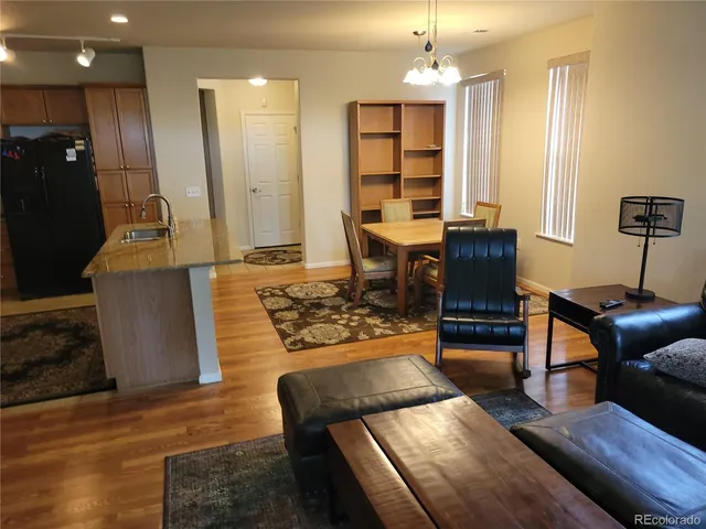 a living room with furniture dining table and a chandelier