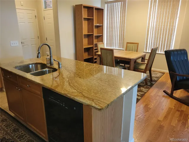 a kitchen with a sink a table and chairs in it