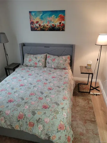 a bed room with a bed and painting on the wall