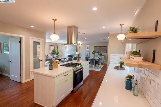 a kitchen with a dining table chairs sink and wooden floor
