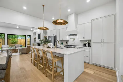 a kitchen with stainless steel appliances a stove a sink a center island and cabinets
