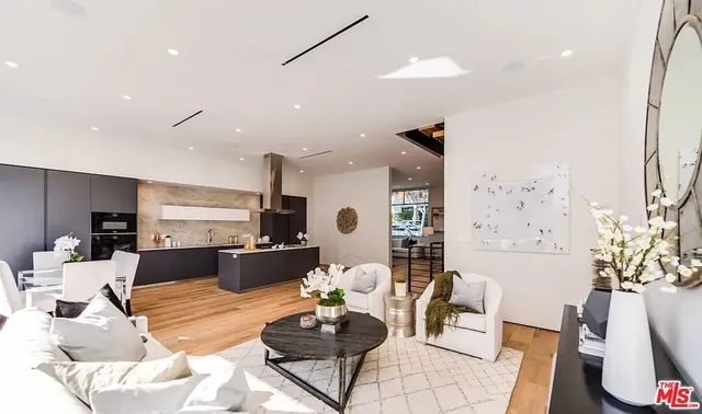 a living room with furniture kitchen and a chandelier