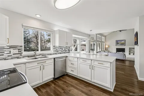 a dining area with stainless steel appliances kitchen island granite countertop a dining table chairs and view living room