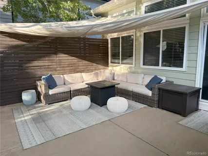 a view of a backyard with table and chairs potted plants and large tree