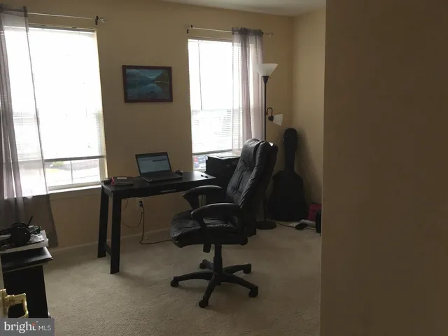 a view of a workspace with furniture and a window