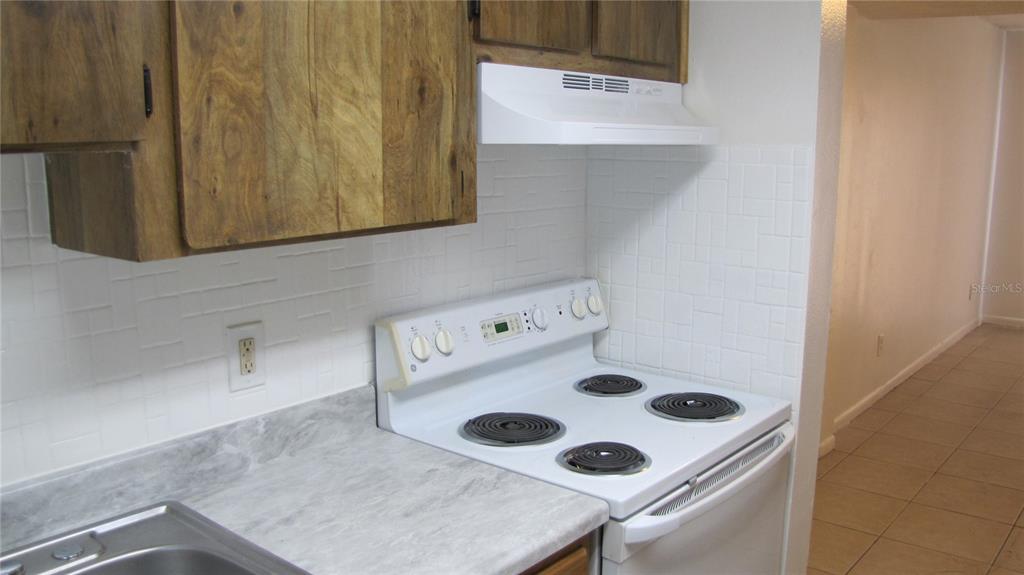 5116 East Temple Heights Road, Unit A Tampa, FL 33617 - Photo 7 of 14 a white cabinet sitting inside of a kitchen