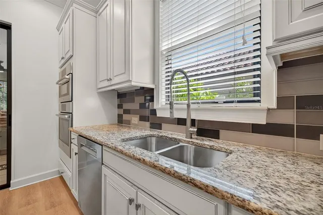a kitchen with granite countertop cabinets stainless steel appliances and a counter space