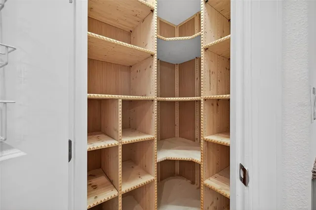 an empty room with wooden floor chandelier fan and windows