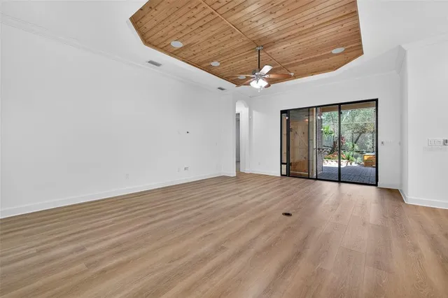 a kitchen with stainless steel appliances kitchen island granite countertop a stove a refrigerator a sink a oven and a wooden cabinets with wooden floor