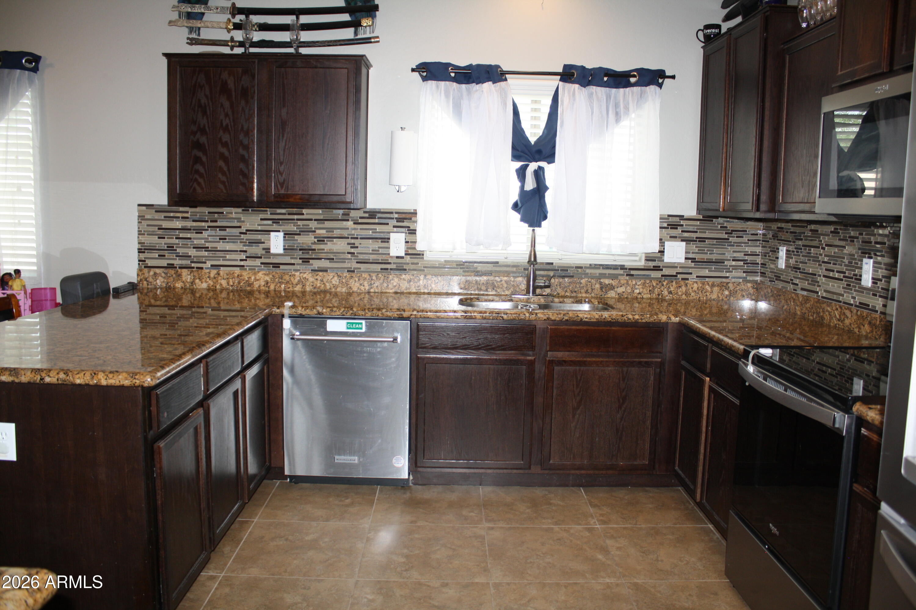 10225 West Camelback Road, Unit 19 Phoenix, AZ 85037 - Photo 8 of 51 a kitchen with stainless steel appliances granite countertop a sink stove and cabinets