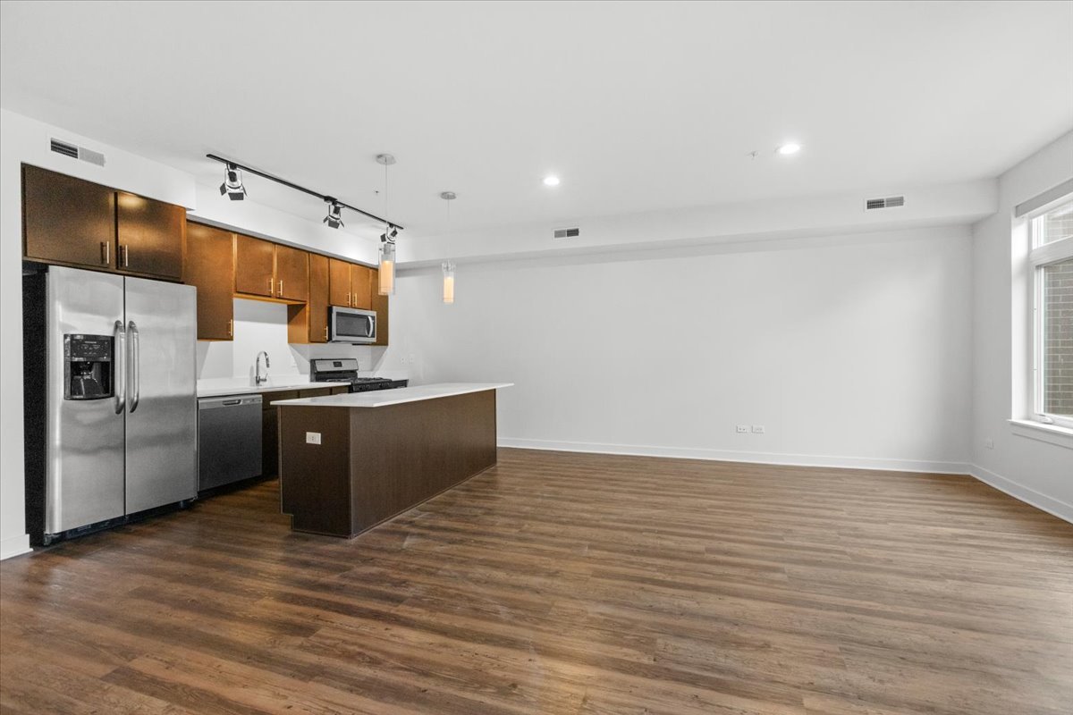 500 North Northwest Highway, Unit 113 Park Ridge, IL 60068 - Photo 3 of 12 a kitchen with stainless steel appliances kitchen island granite countertop a stove a sink and a refrigerator