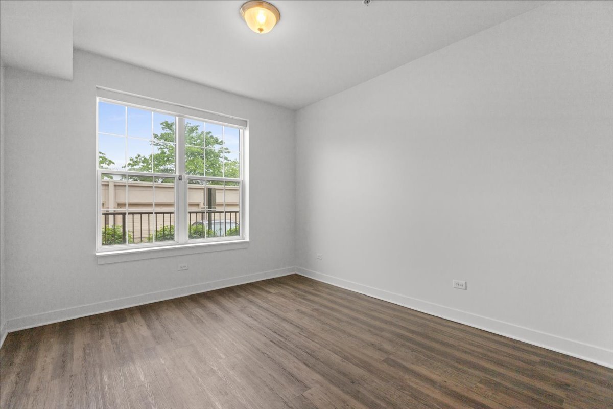 500 North Northwest Highway, Unit 113 Park Ridge, IL 60068 - Photo 5 of 12 an empty room with wooden floor and windows
