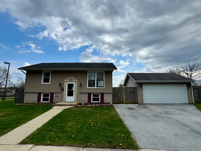 a front view of a house with a garden and yard