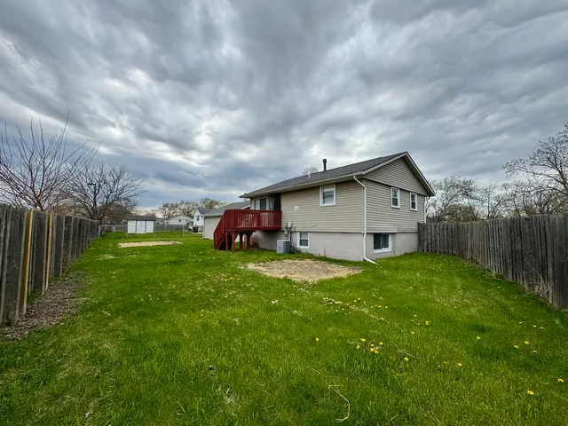 a view of a house with a big yard potted plants and large trees