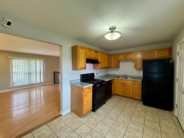 a kitchen with granite countertop a refrigerator a stove top oven and a refrigerator