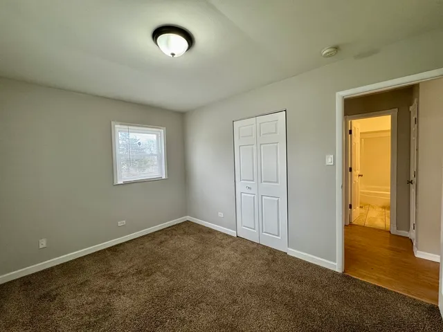 an empty room with a door and wooden floor