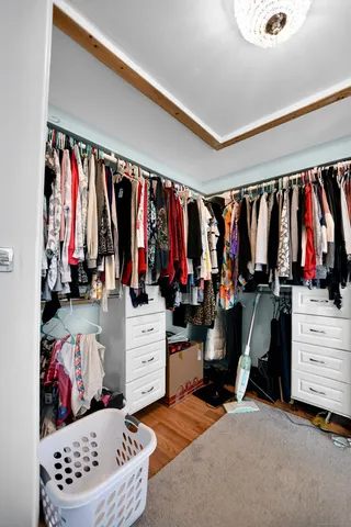 a view of walk in closet with clothes and shoes