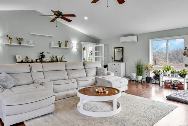 a living room with furniture and a wooden floor