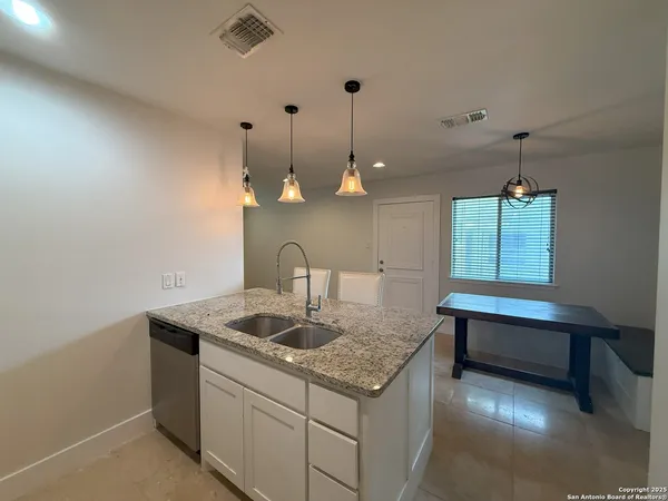 a kitchen with a sink cabinets and wooden floor