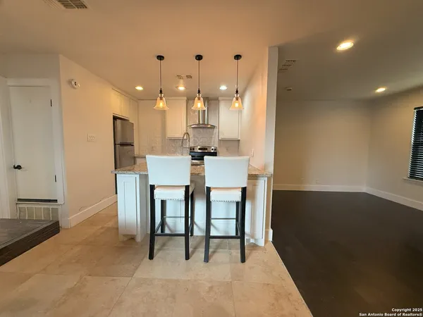 a dining hall with stainless steel appliances a table and chairs