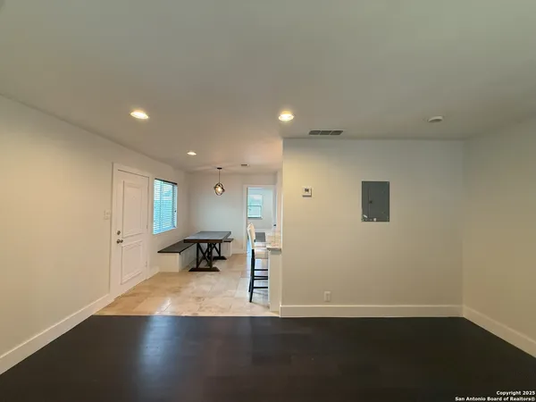 an empty room with wooden floor and a bench