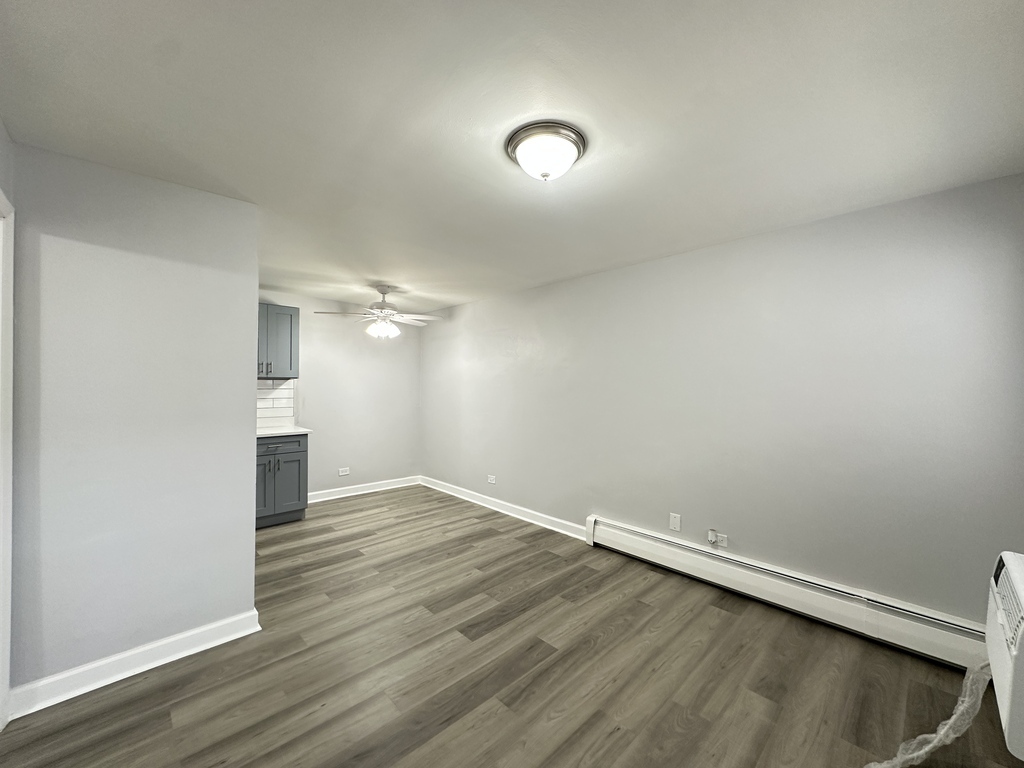 4616 North Beacon Street, Unit 2F Chicago, IL 60640 - Photo 11 of 21 an empty room with wooden floor and windows