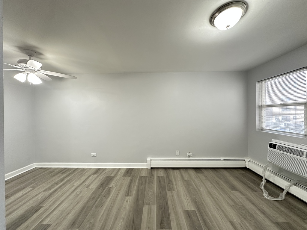 4616 North Beacon Street, Unit 2F Chicago, IL 60640 - Photo 12 of 21 wooden floor in an empty room with a window