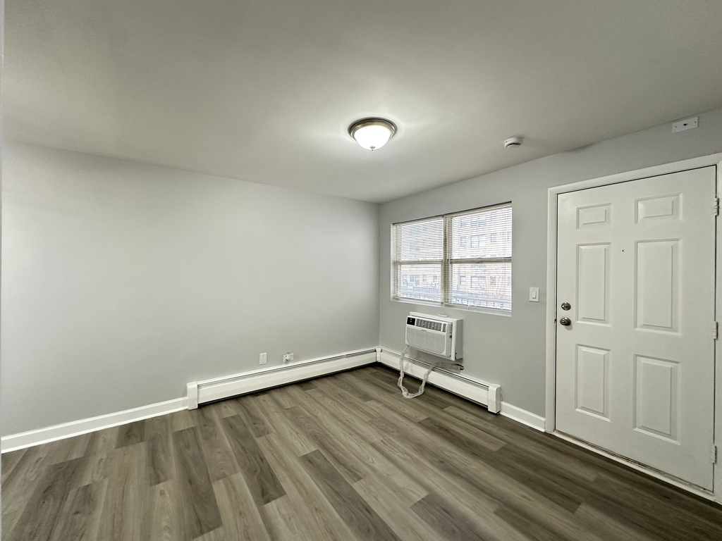 4616 North Beacon Street, Unit 2F Chicago, IL 60640 - Photo 13 of 21 an empty room with wooden floor and windows