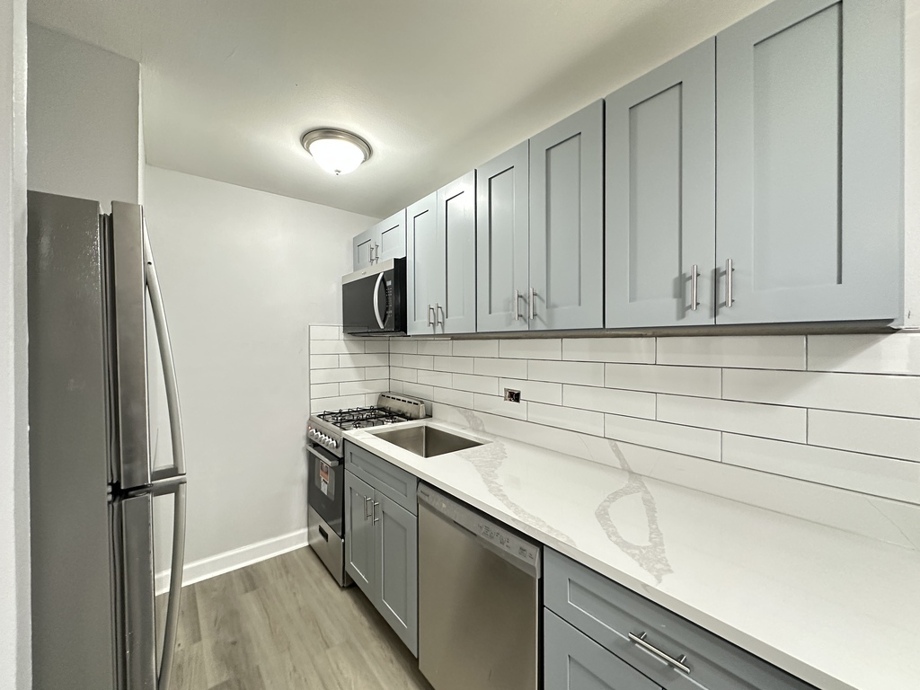 4616 North Beacon Street, Unit 2F Chicago, IL 60640 - Photo 3 of 21 a kitchen with stainless steel appliances granite countertop white cabinets and refrigerator