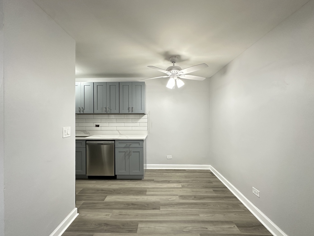 4616 North Beacon Street, Unit 2F Chicago, IL 60640 - Photo 6 of 21 a view of an empty room with wooden floor and a kitchen