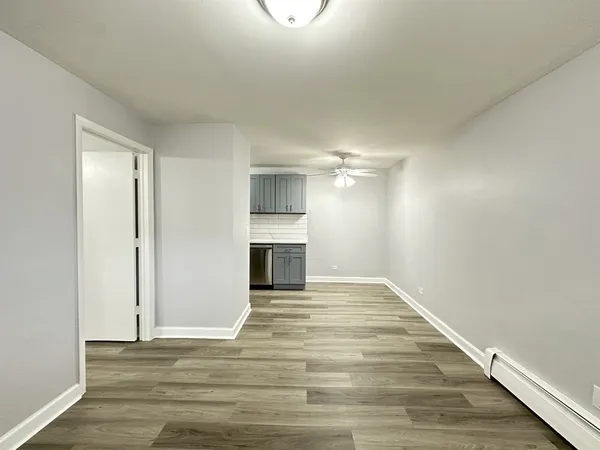 a view of empty room with wooden floor