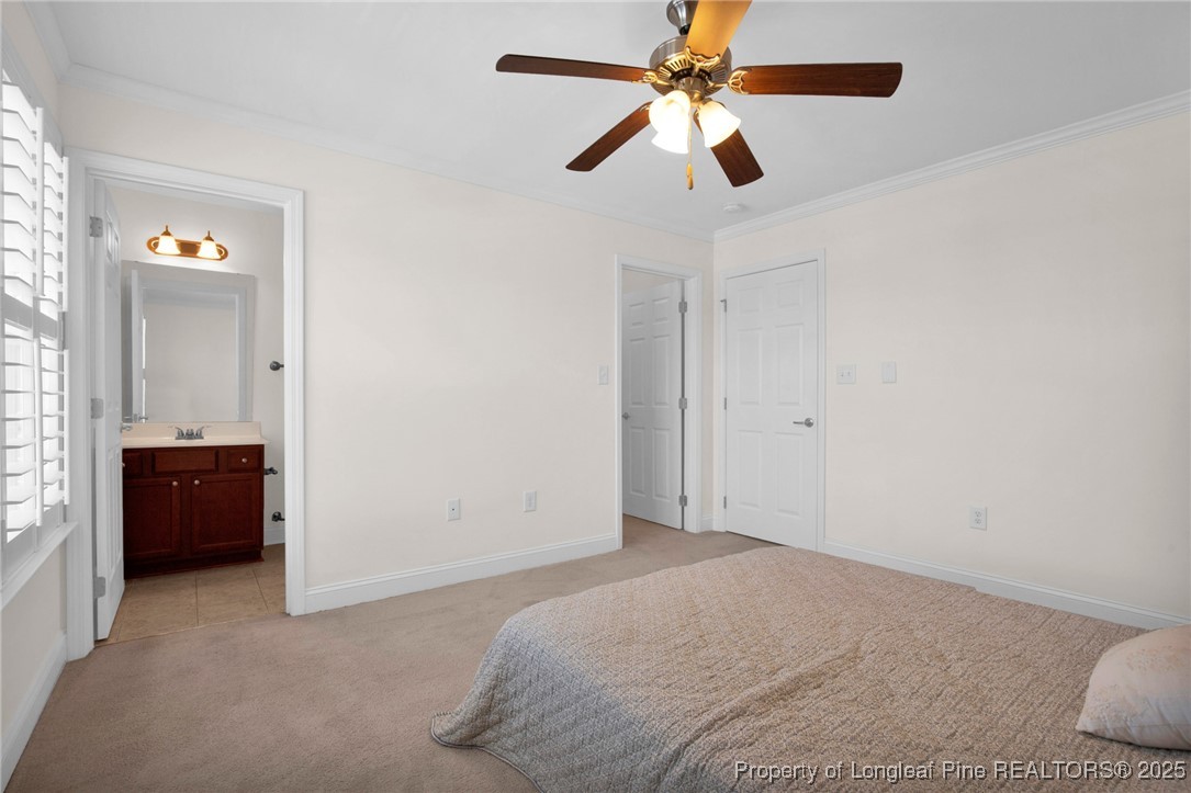 28 Hunter's Run Avenue Pembroke, NC 28372 - Photo 28 of 32 a bedroom with a bed and a chandelier fan