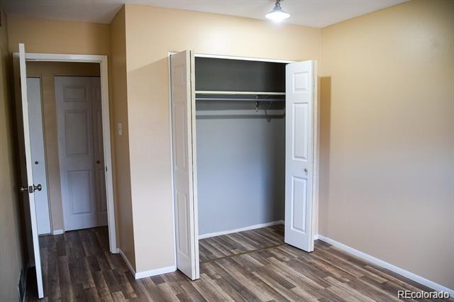 1225 South Oneida Street, Unit 252 Denver, CO 80224 - Photo 13 of 20 a view of an empty room with wooden floor and a hallway