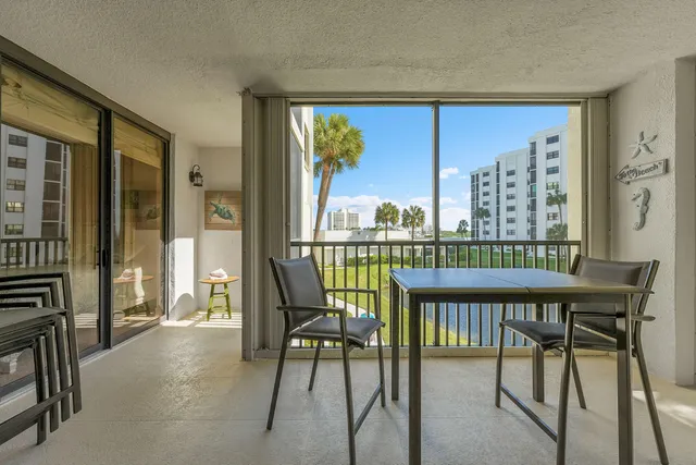 a view of a balcony with furniture and a floor to ceiling window
