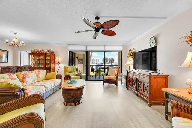 a living room with furniture a flat screen tv and a chandelier