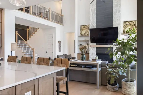 a kitchen with stainless steel appliances kitchen island granite countertop a table chairs and a refrigerator