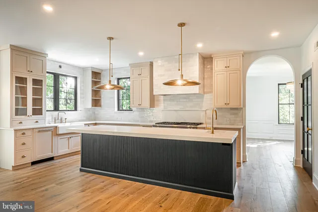 a kitchen with stainless steel appliances granite countertop a sink a stove and a wooden floors