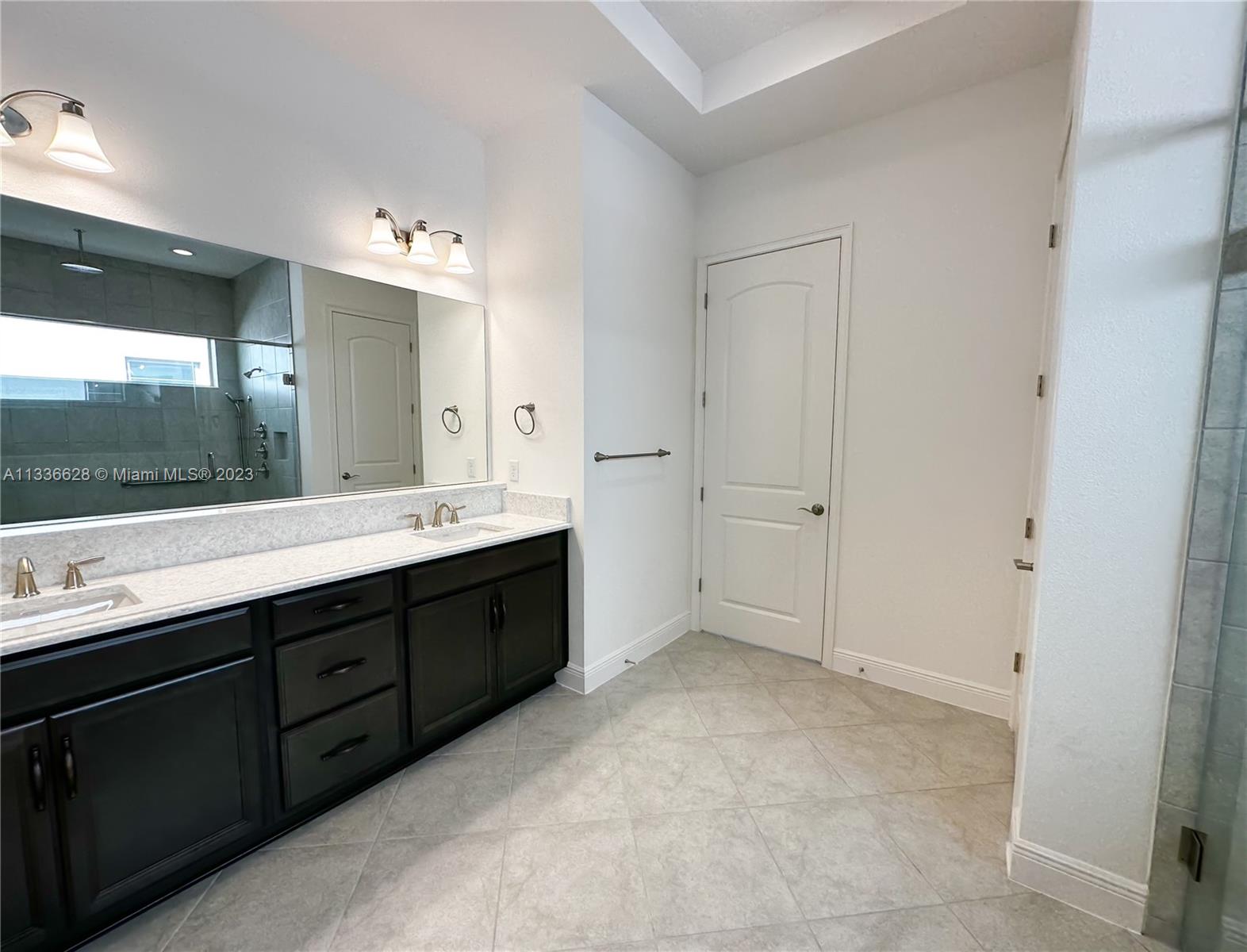 13646 Abberwick Drive Orlando, FL 32832 - Photo 17 of 50 a spacious bathroom with a double vanity sink a large mirror and a bathtub