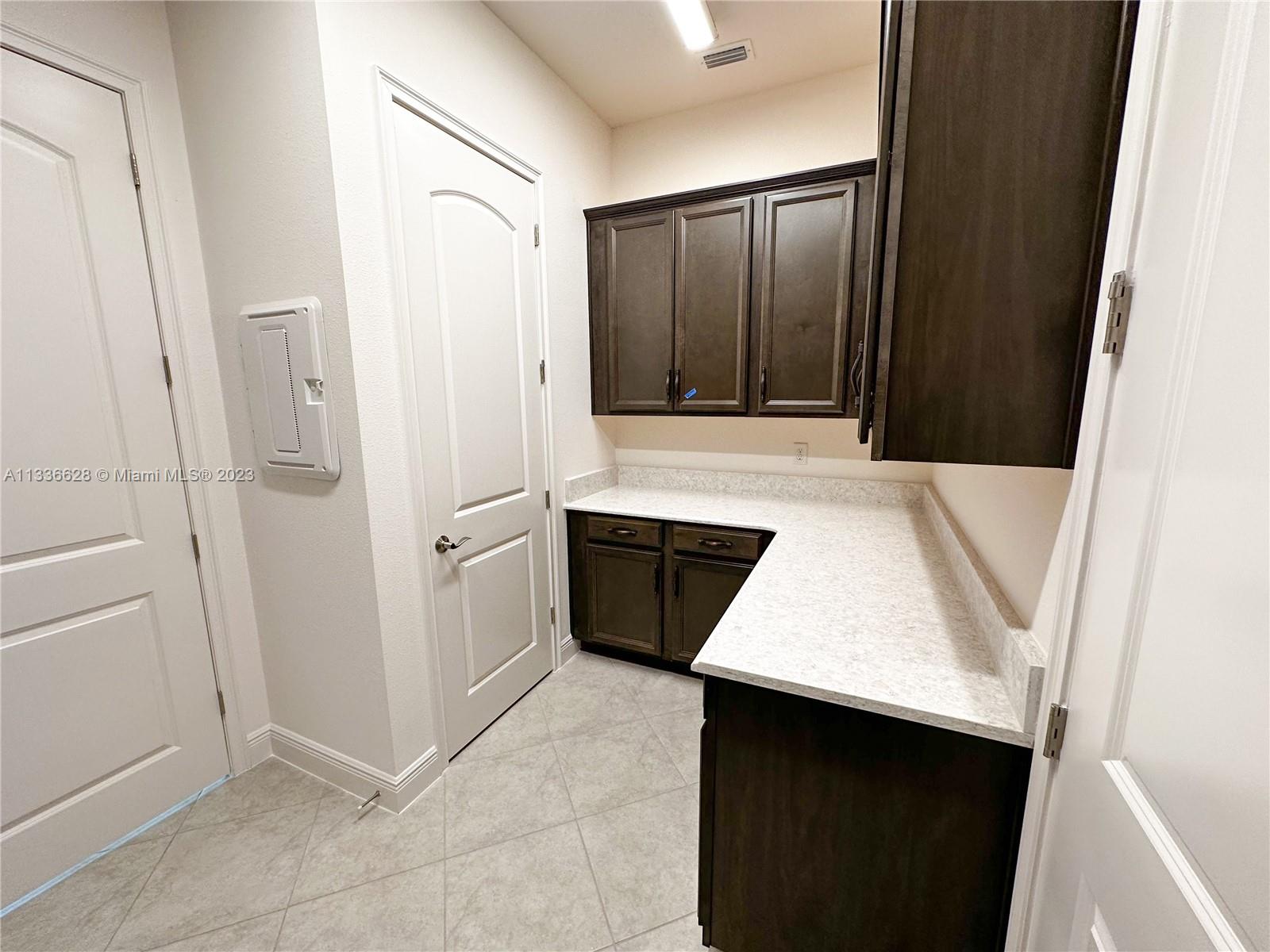 13646 Abberwick Drive Orlando, FL 32832 - Photo 18 of 50 a kitchen with white cabinets and white appliances