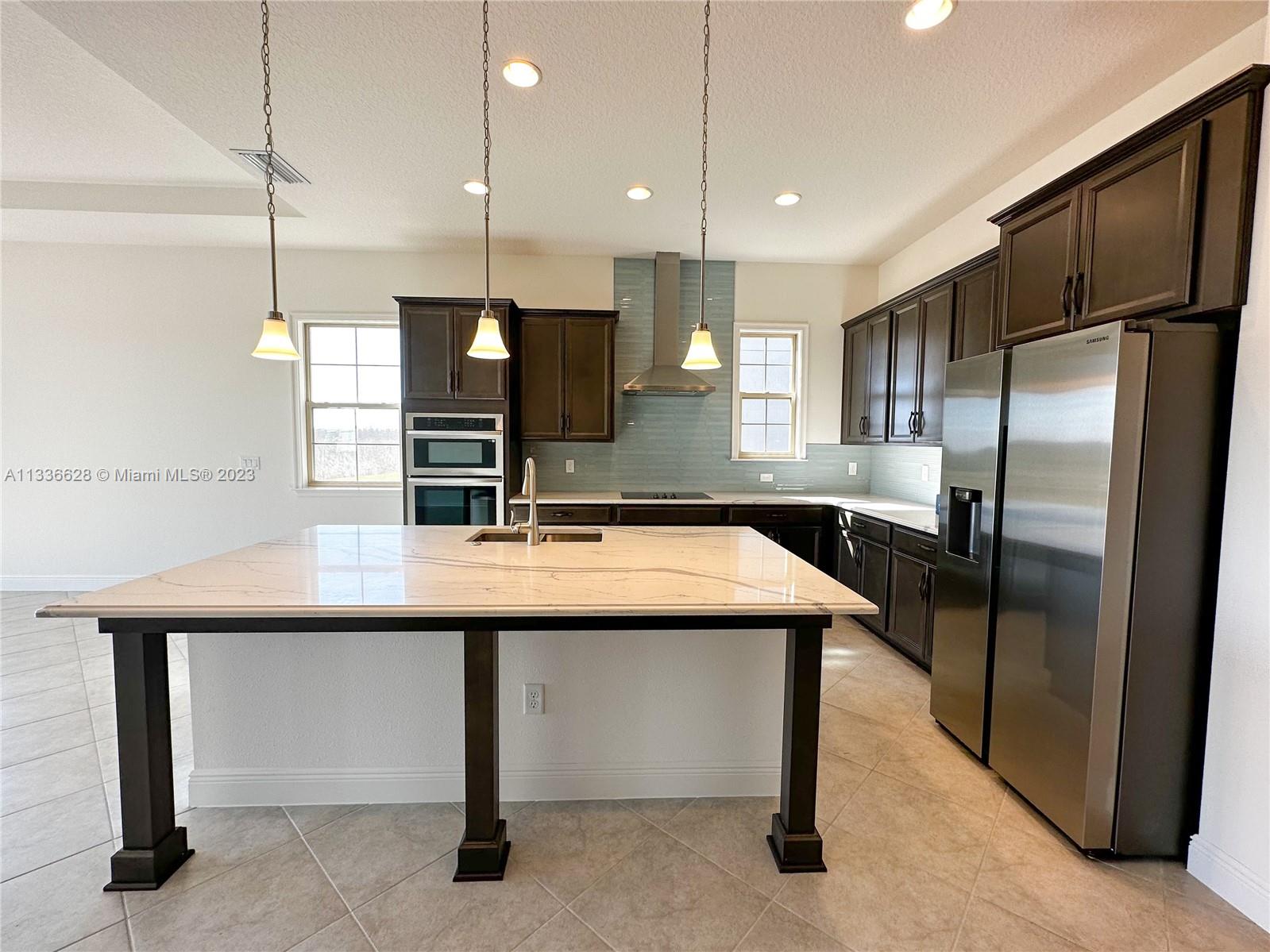 13646 Abberwick Drive Orlando, FL 32832 - Photo 2 of 50 a kitchen with kitchen island a sink appliances and cabinets
