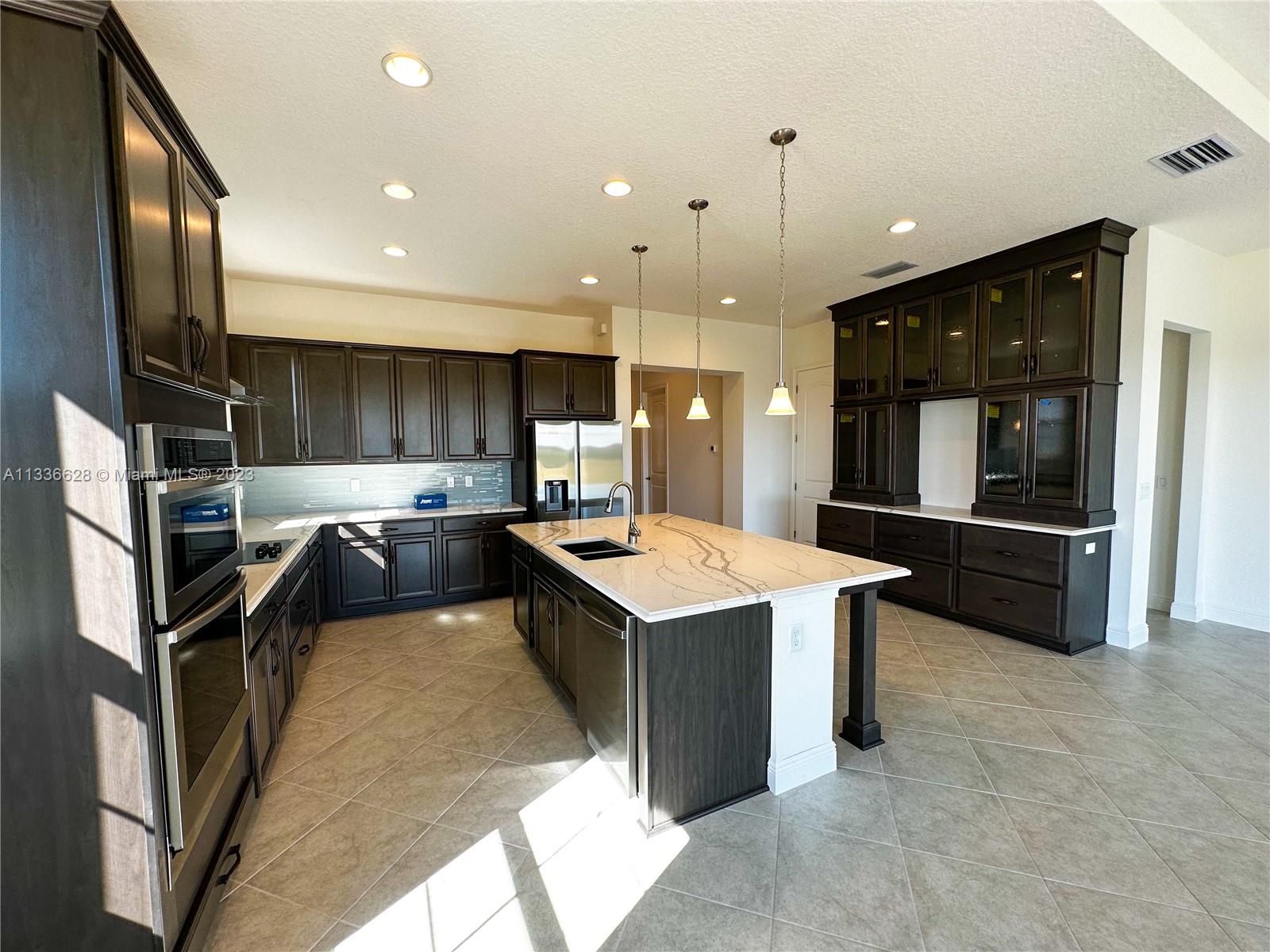 13646 Abberwick Drive Orlando, FL 32832 - Photo 22 of 50 a kitchen with a stove a refrigerator and a sink
