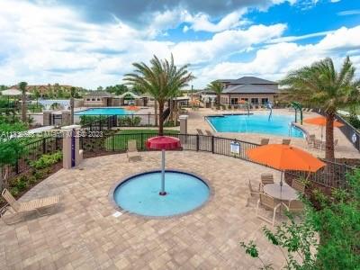 13646 Abberwick Drive Orlando, FL 32832 - Photo 33 of 50 a view of a swimming pool with a table and chairs