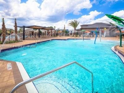 13646 Abberwick Drive Orlando, FL 32832 - Photo 46 of 50 a view of a swimming pool with a garden and trees