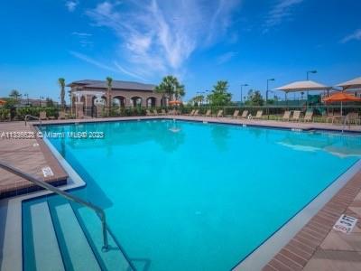 13646 Abberwick Drive Orlando, FL 32832 - Photo 49 of 50 a view of a swimming pool with lawn chairs