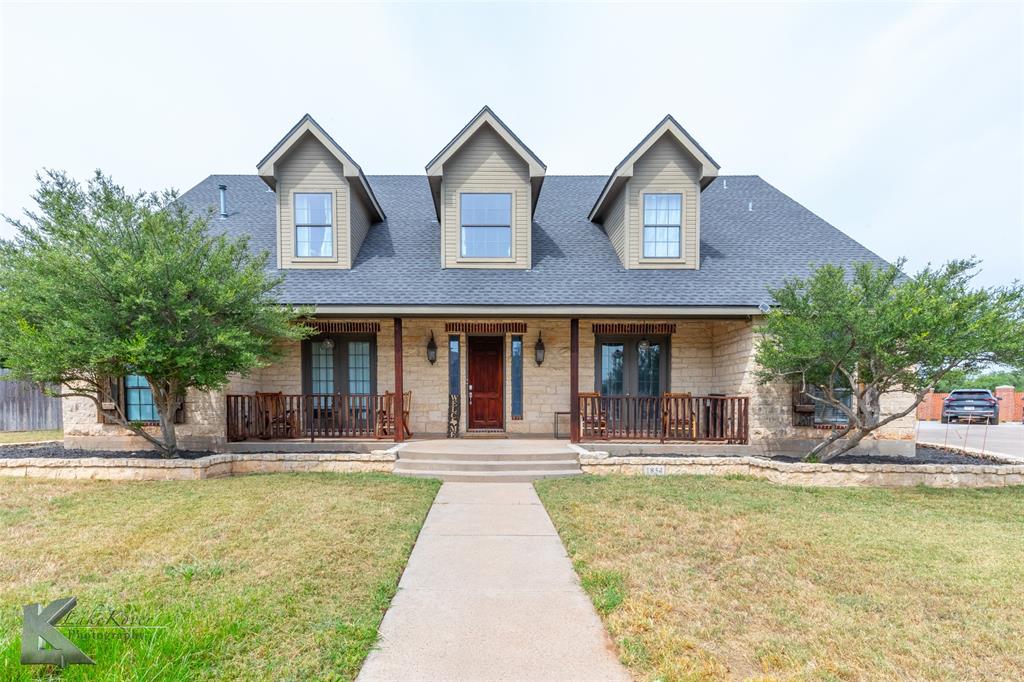 a front view of a house with swimming pool and chairs