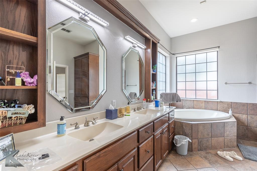 1834 Marathon Court Abilene, TX 79601 - Photo 16 of 39 a bathroom with a double vanity sink bathtub and a large mirror