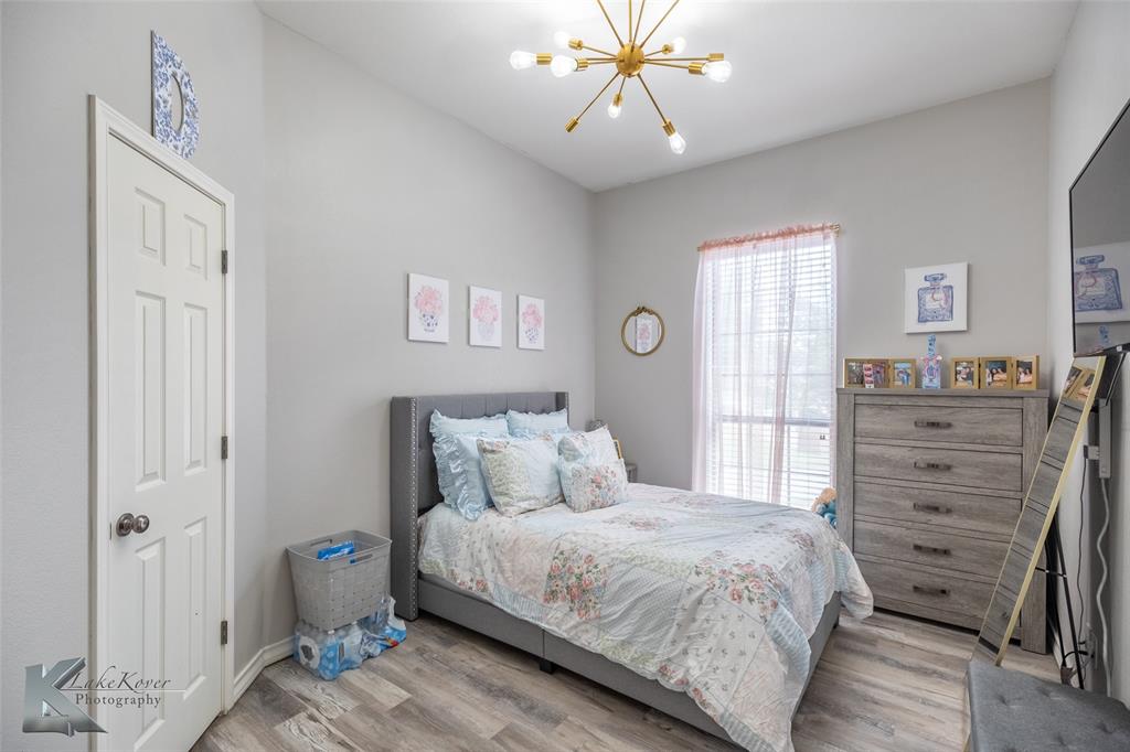 1834 Marathon Court Abilene, TX 79601 - Photo 24 of 39 a bedroom with a large bed and a chandelier