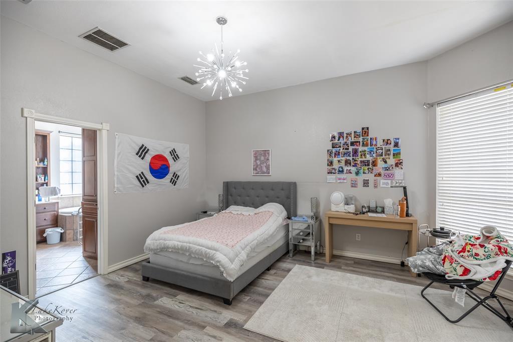 1834 Marathon Court Abilene, TX 79601 - Photo 26 of 39 a bedroom with a bed and a chandelier