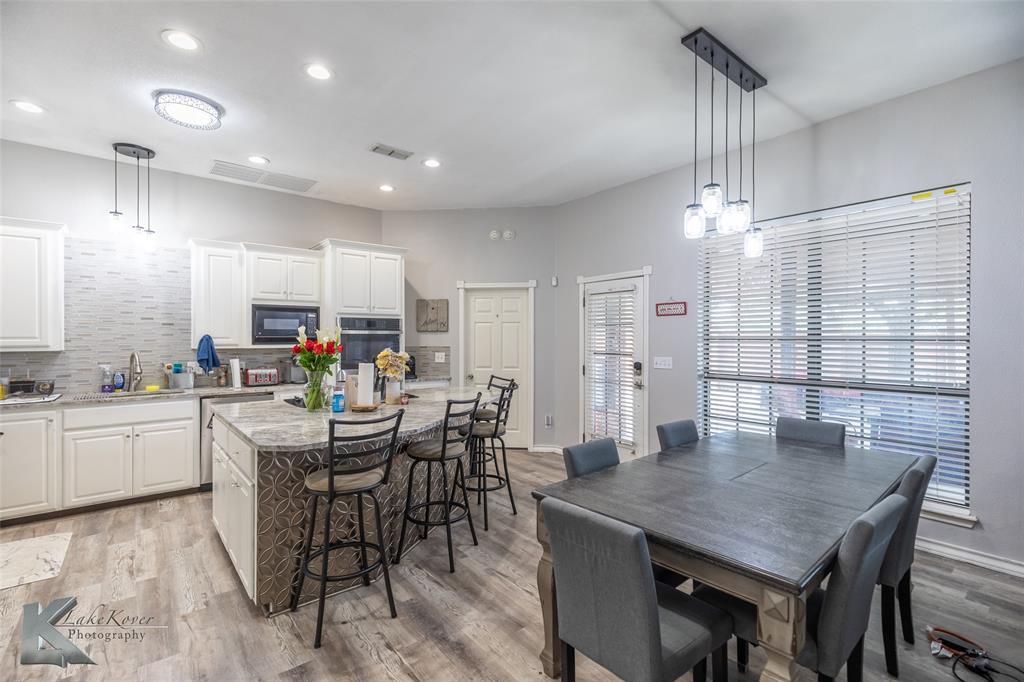1834 Marathon Court Abilene, TX 79601 - Photo 9 of 39 a kitchen with stainless steel appliances kitchen island granite countertop a dining table chairs and white cabinets